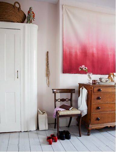 A chair is in front of the Diy large canvas drop cloth wall art.