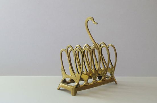 A gold brass letter holder shaped as a swan.