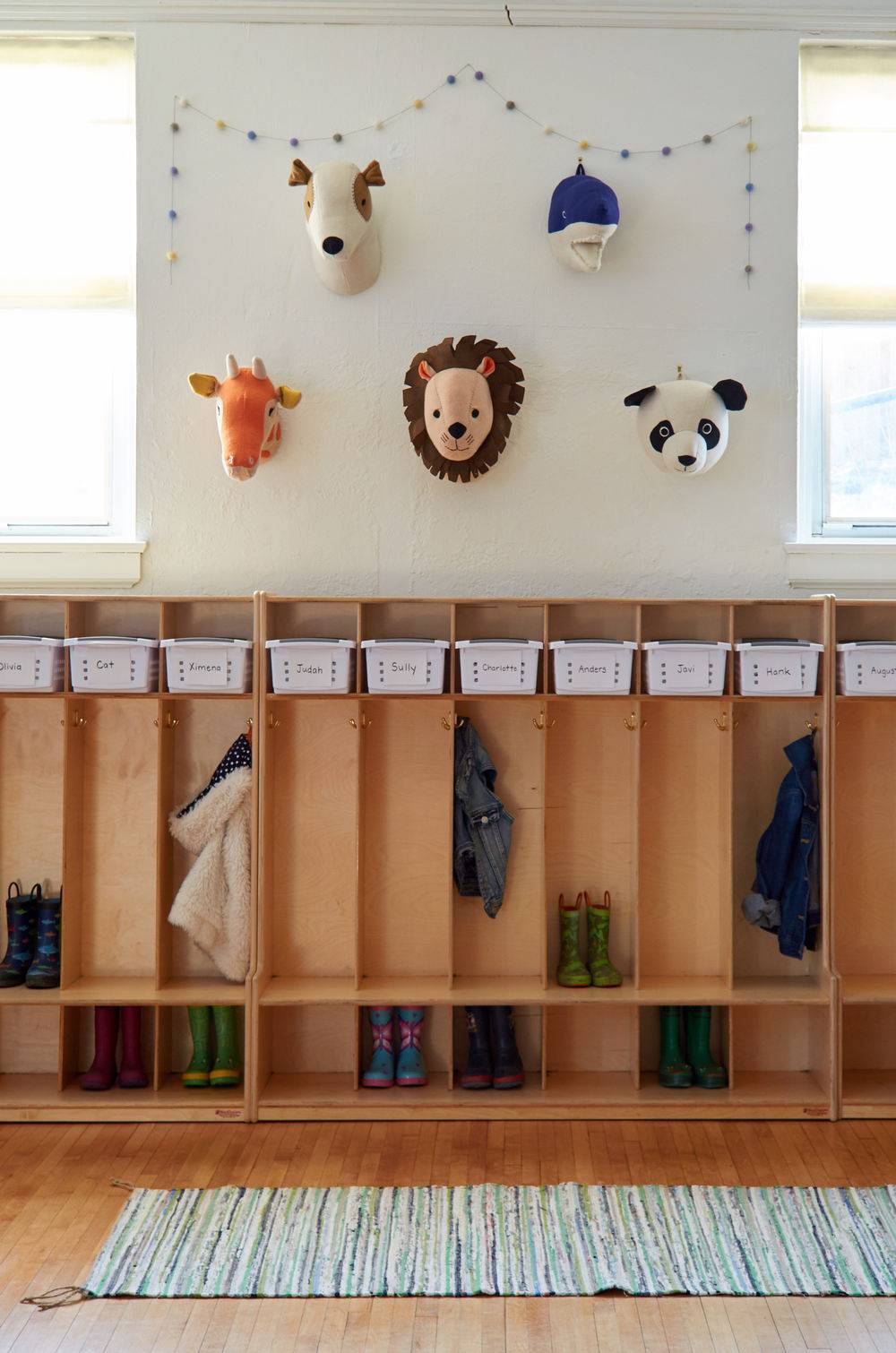 A nursery school with animal heads over a clothes storage area.