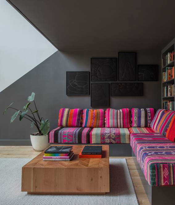 Colorful couch with wooden table and potted plant aside in the living room.