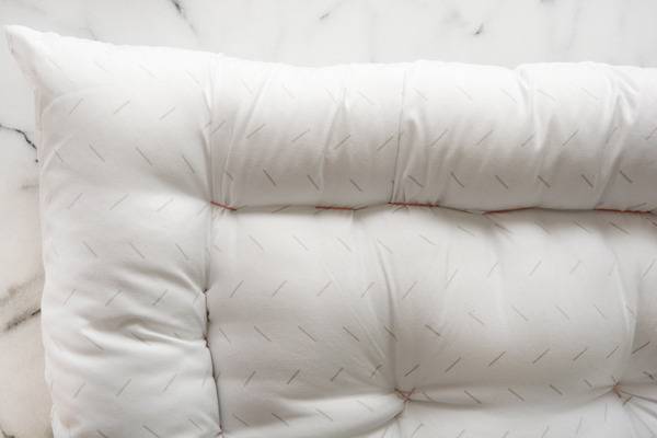 The corner of a fluffy white pet bed.