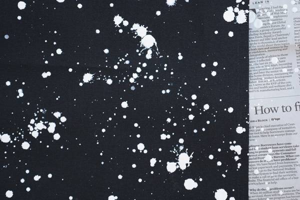 Book pages being covered by a black piece of paper with white spots on it.