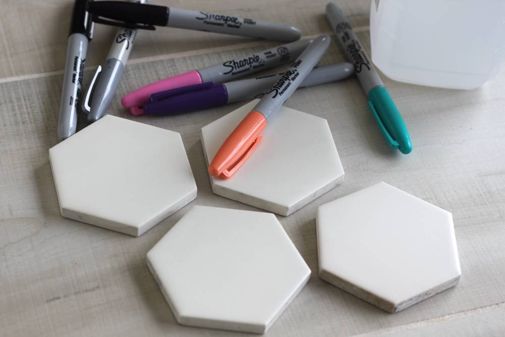 You'll need Markers, ceramic tiles, rubbing alcohol, felt, and dishwasher safe Mod Podge.