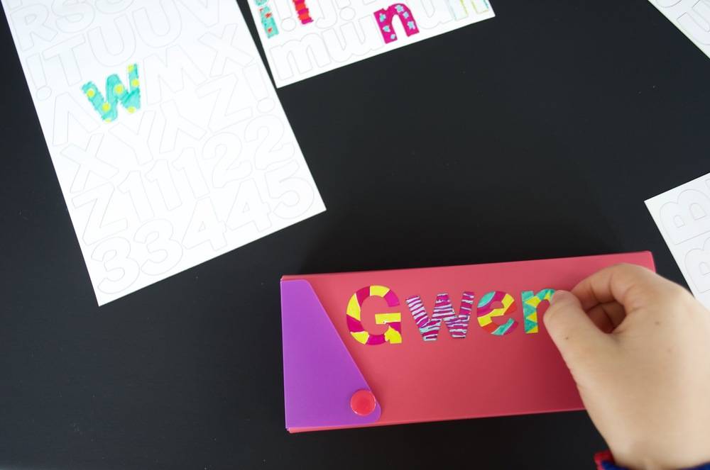 Construction paper with various colored letters used to design an ornamental piece.