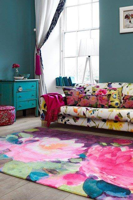 Painted rug on the floor of the living room and a sofa is placed near the rug.