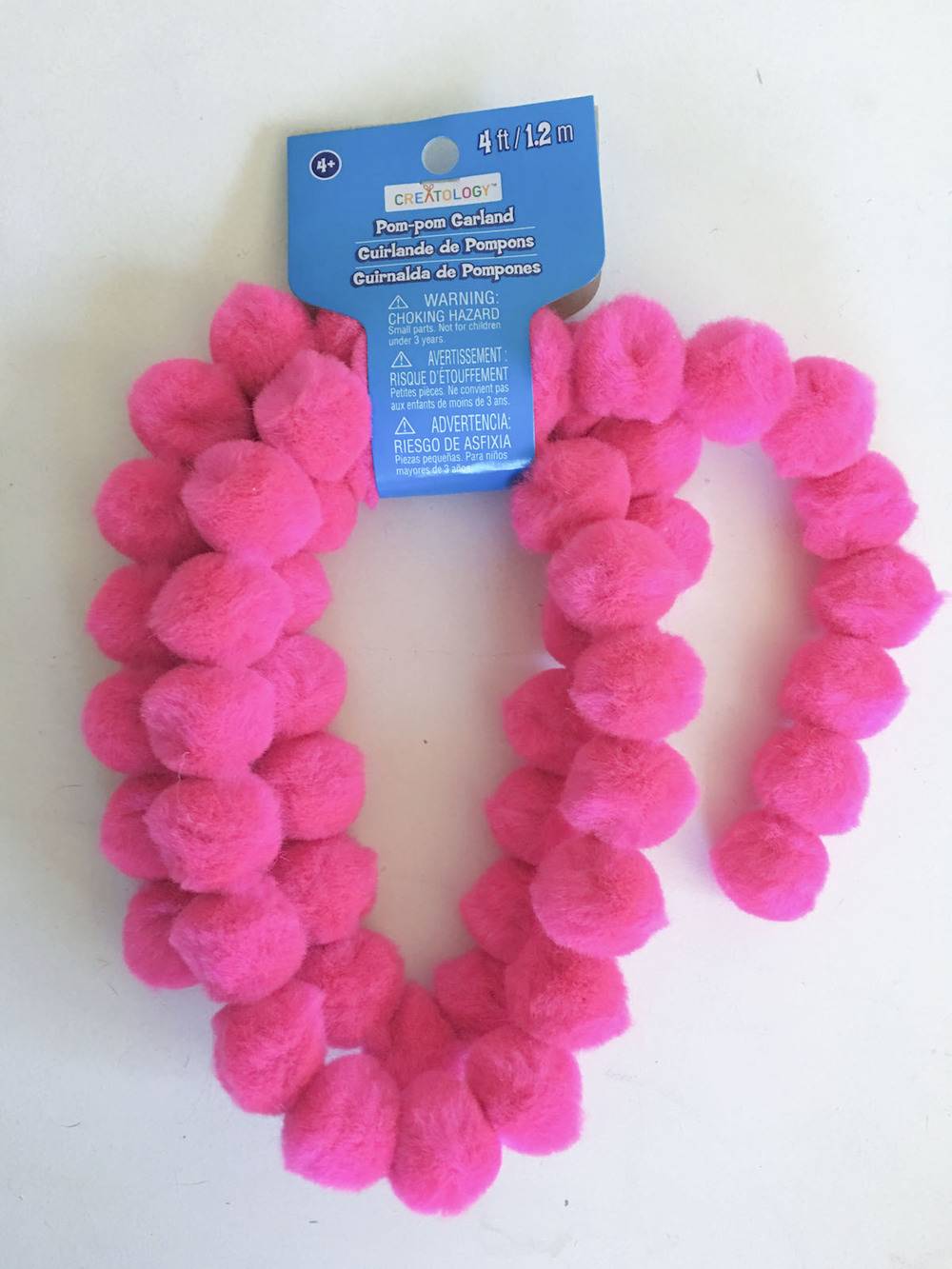 A line of pink puffs rolled up and clasped by a blue tag.