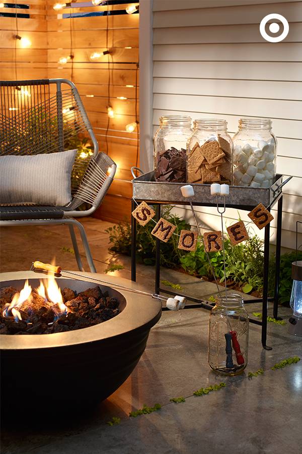 A small fire pit is lit on a patio with tile flooring.