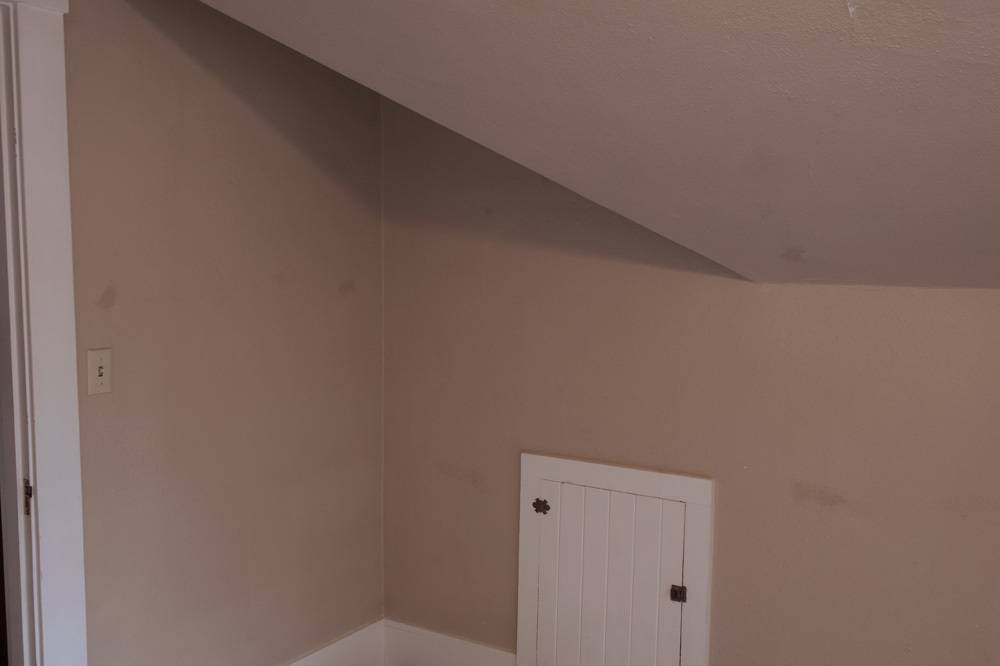 A beige wall and ceiling near a white door