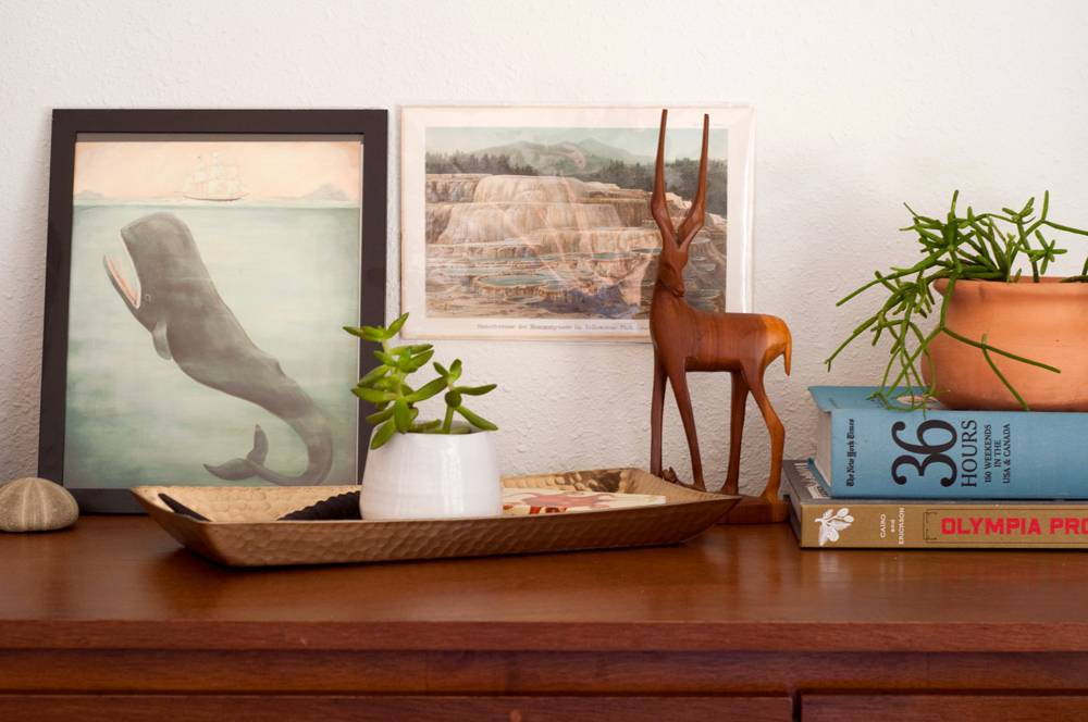 A cute simple decorated end table with plants and books.