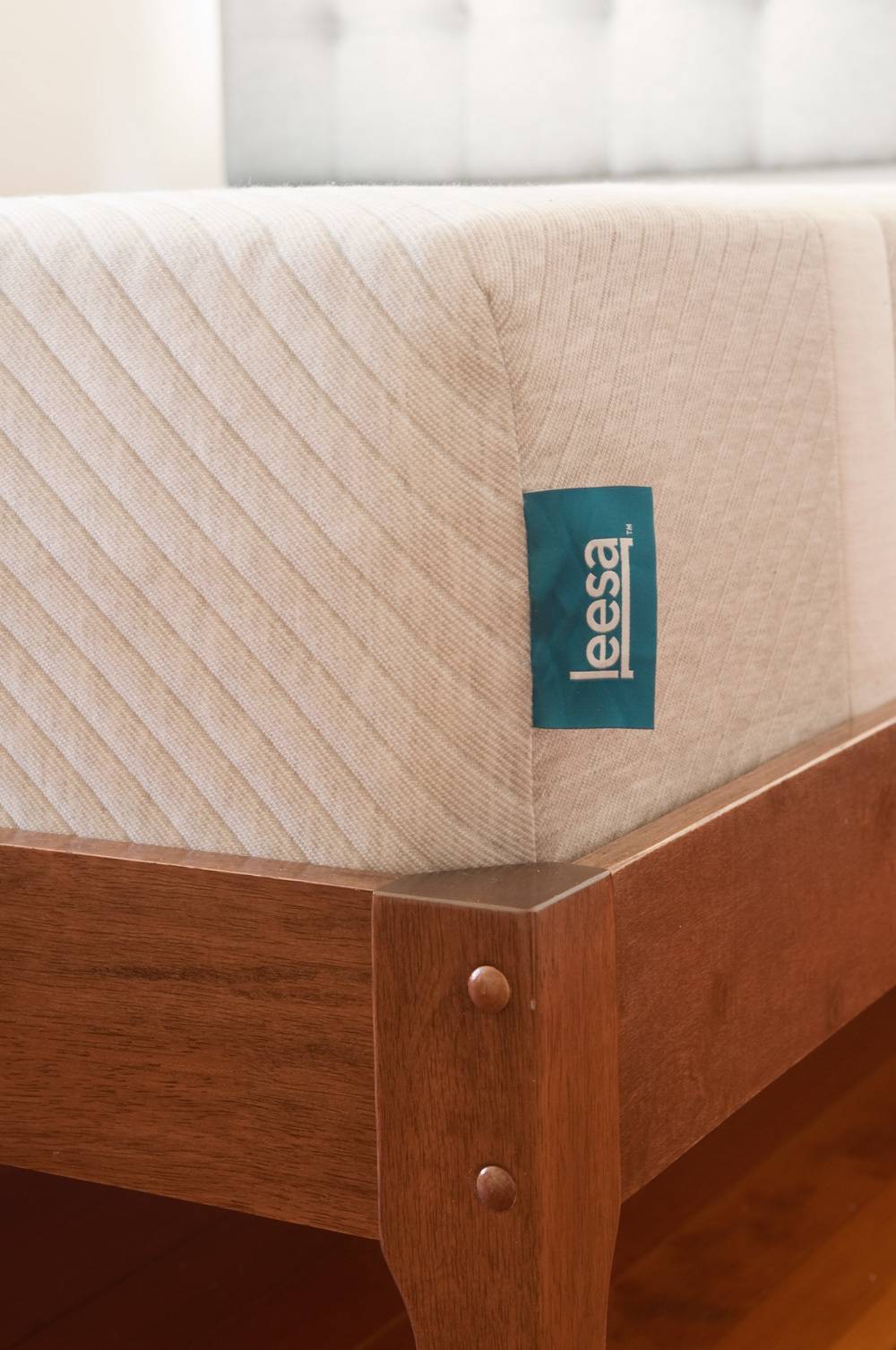 A blue tag is on the corner of a mattress.