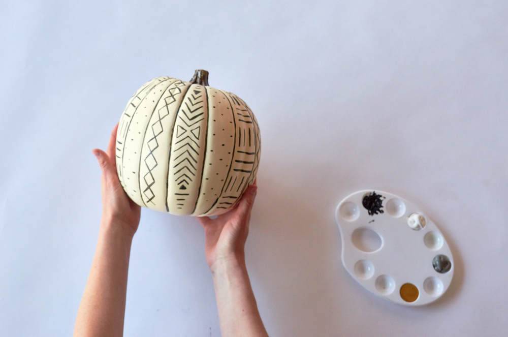 Pumpkin is decorated with different designs and colors.