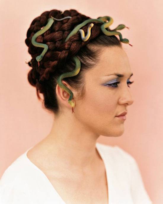 A woman made up with snakes in her hair like Medusa.
