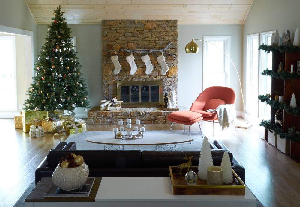 A cosey warm living room with christmas tree on the side and an orange chair