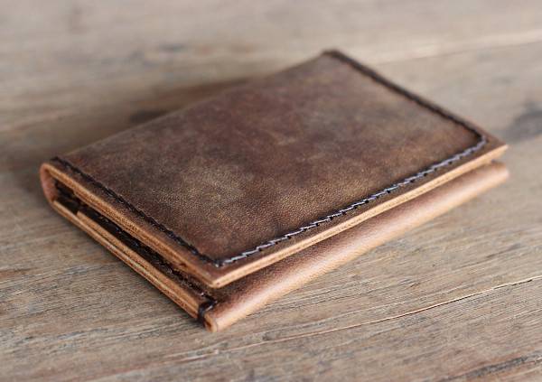 A light brown leather wallet with a worn look.