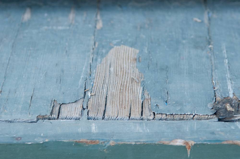 Chipped and weathered blueish gray wooden slats.
