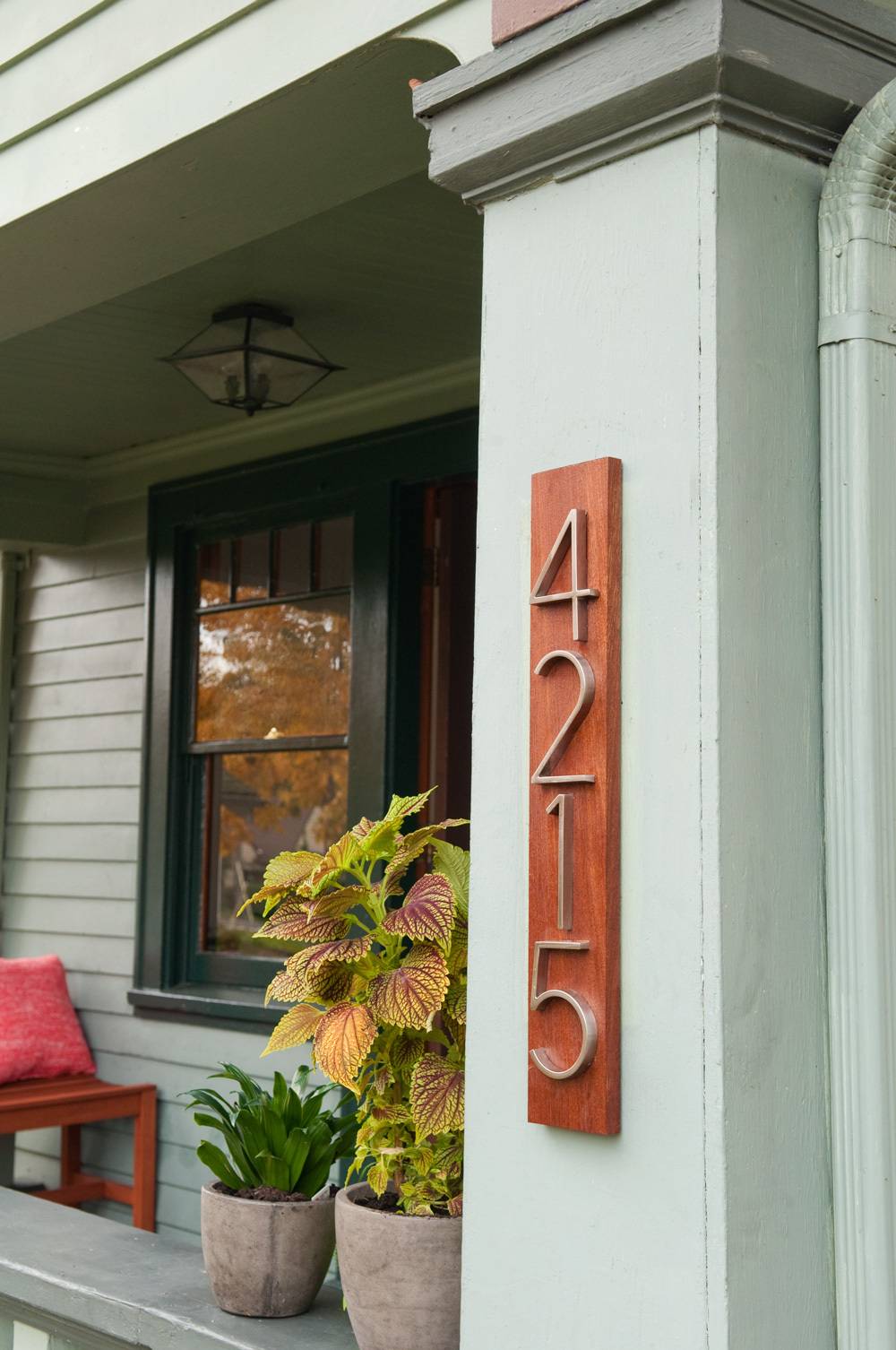 The number 4210 on the side of a house with a porch.