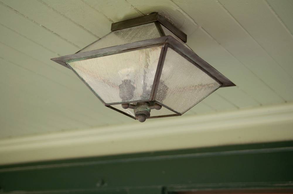 Lamp shaped shandler is hanging to the ceiling.