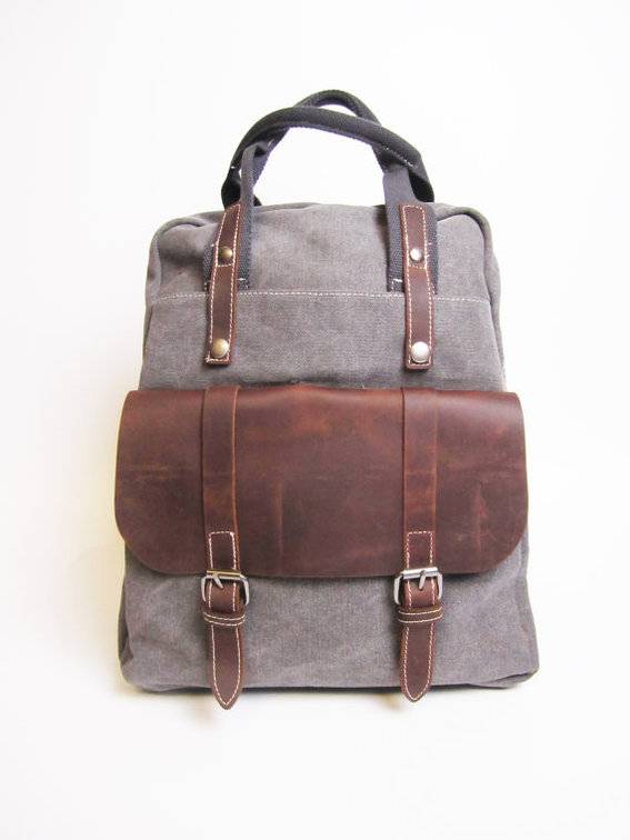 A grey satchel with brown leather accents and straps.