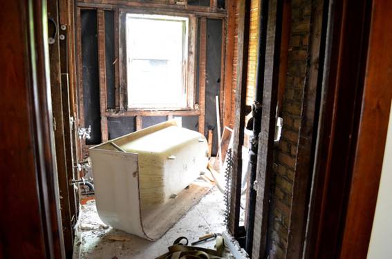 Tub sitting on its side in a room that has been demoed.