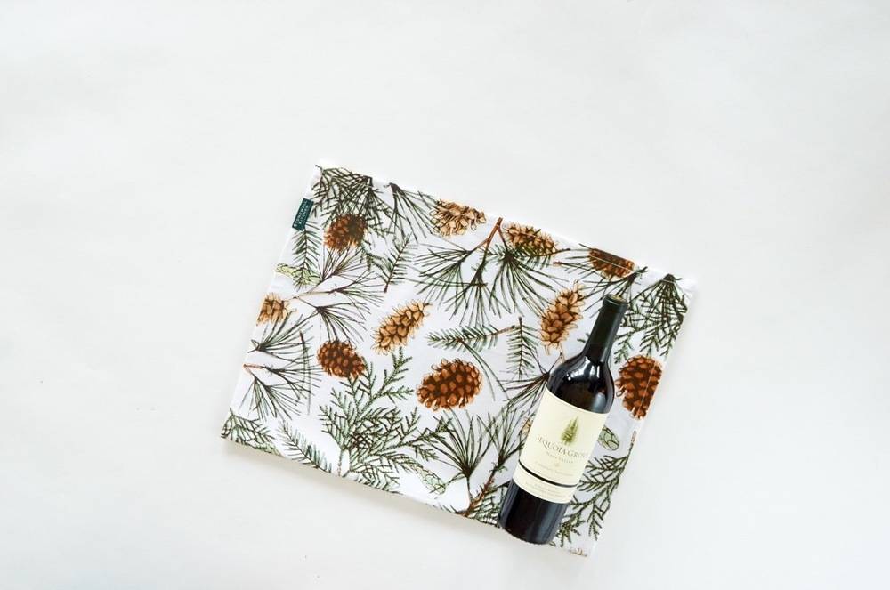 A napkin with a colorful design that shows flowers and wine