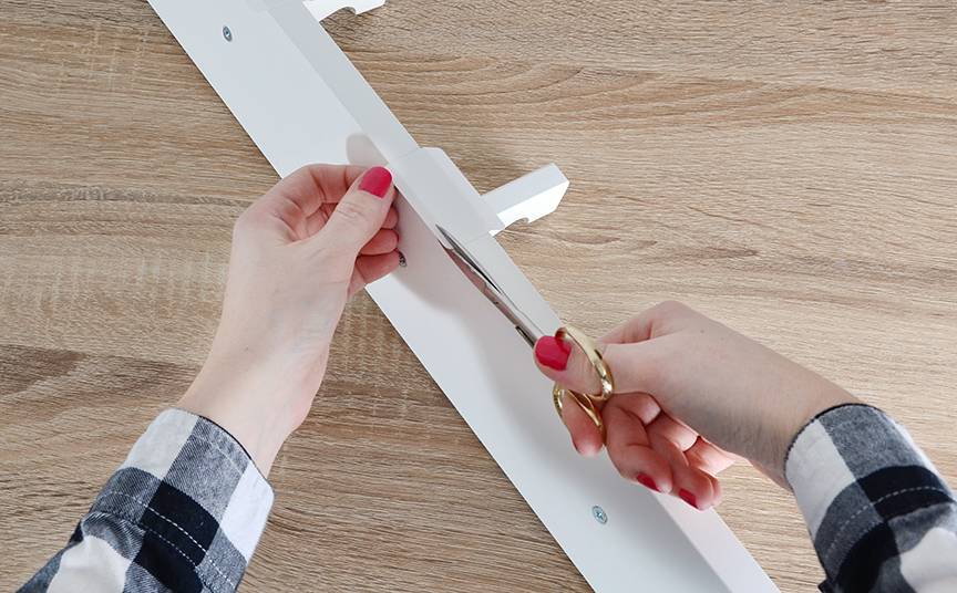 a woman cutting side of a desk with scissors
