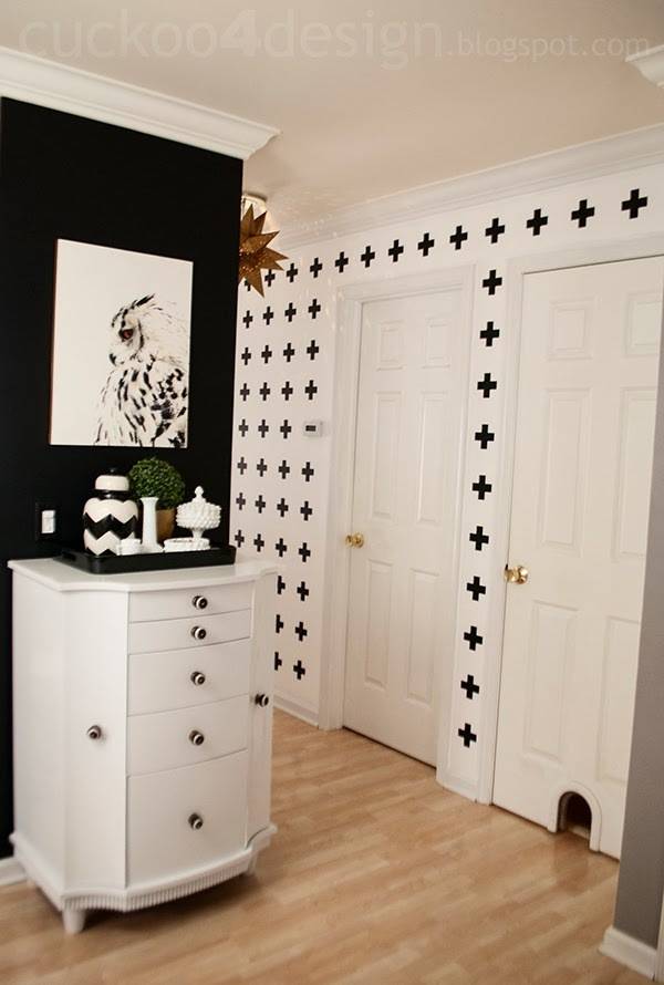 A room with black and white painted walls and wooden floors.