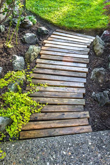 Wooden planks stained walnut lead through a small garden.