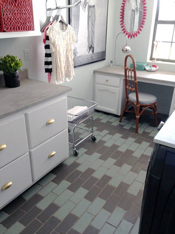 A laundry room with clothes hanging and a table to sit at with a red chair.