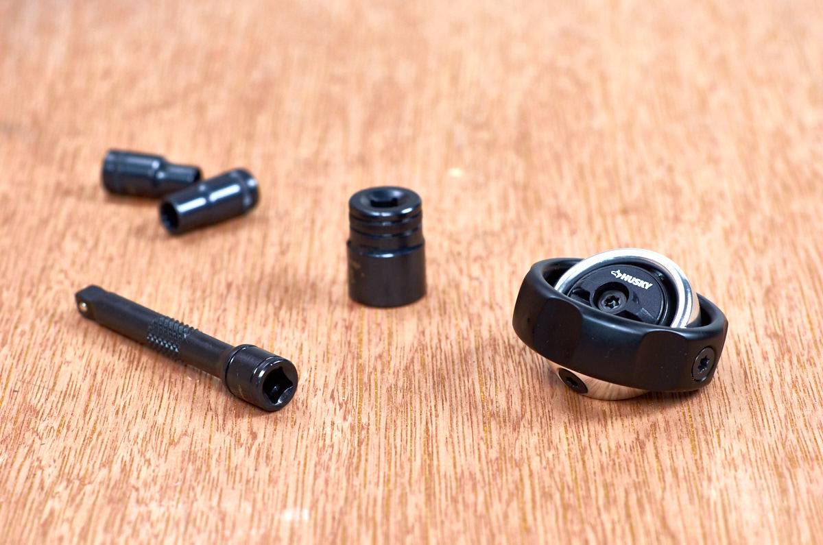 Tiny black flashlight broken down into several pieces on top of a wooden table.
