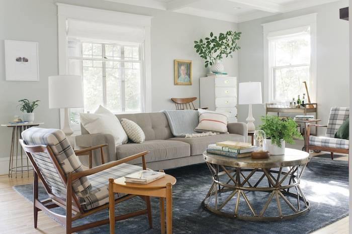 A living room with neutral colored furniture and bright, airy windows.