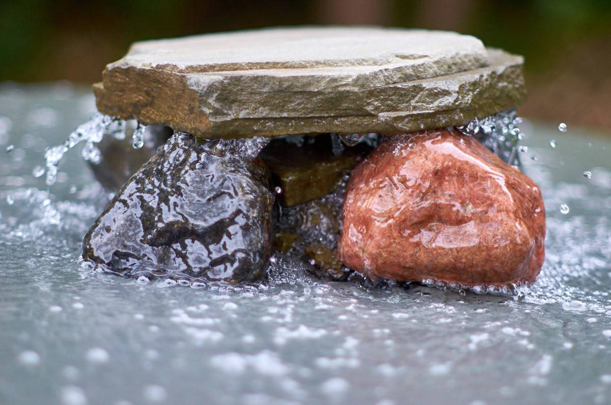 A flat stone sits on several rocks.