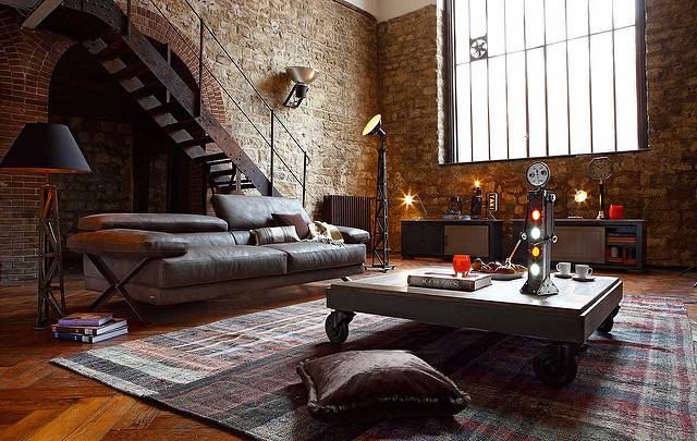 Living room filled with furniture in a sunlit loft.