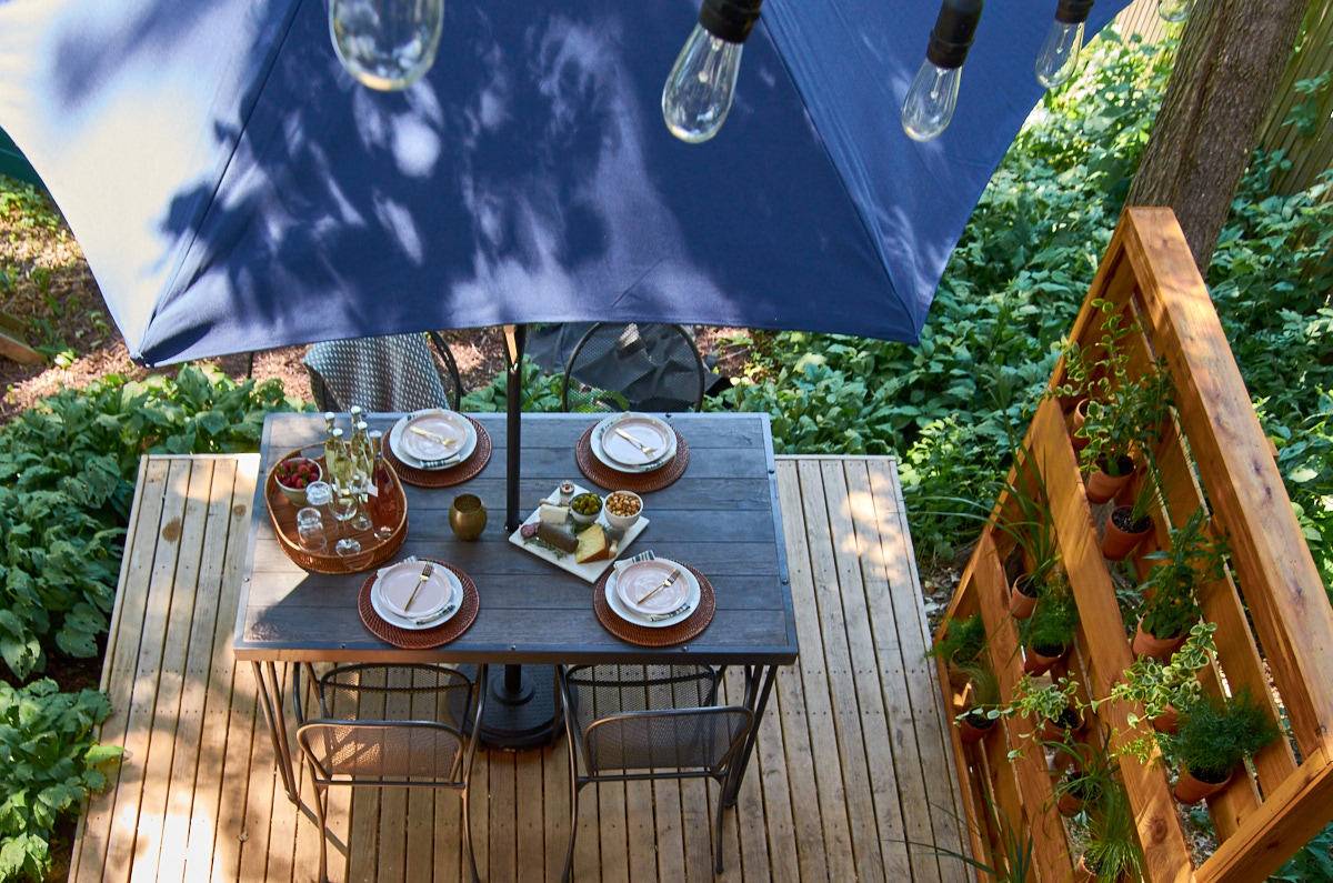 Outdoor dinning table with dishes on the table with umbrella.