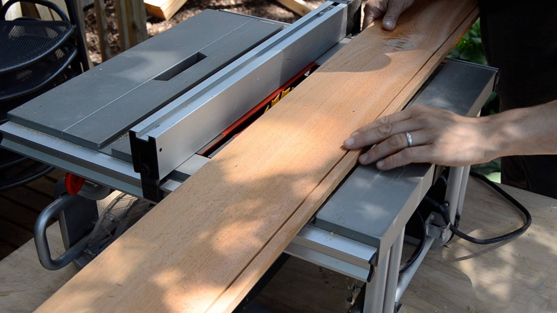 A person is trimming wood using a machine.