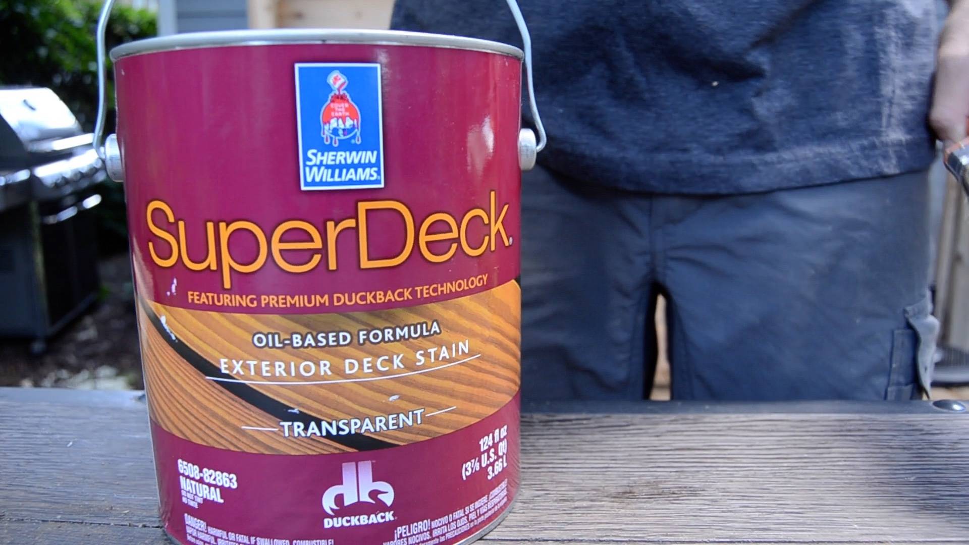 Man putting super deck oil based paint tin on the table.