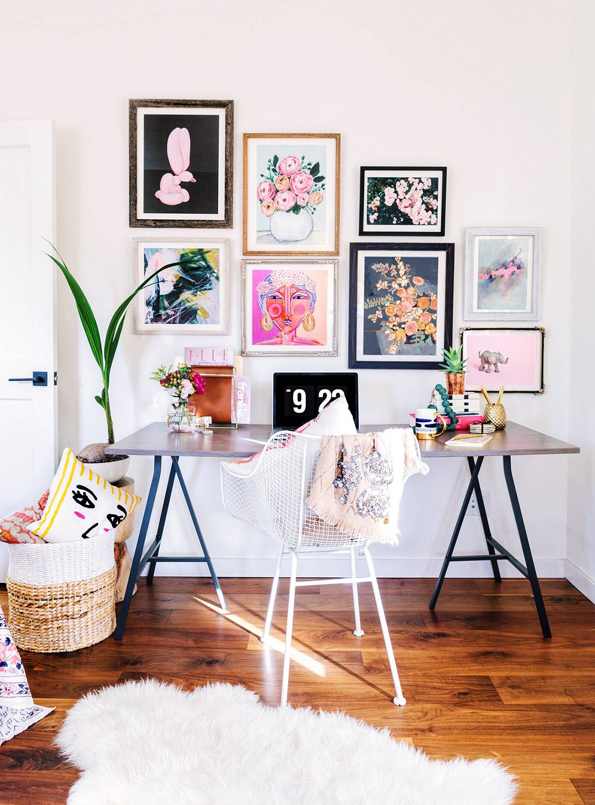 Pictures are hanging on a wall in a room with a wooden floor.