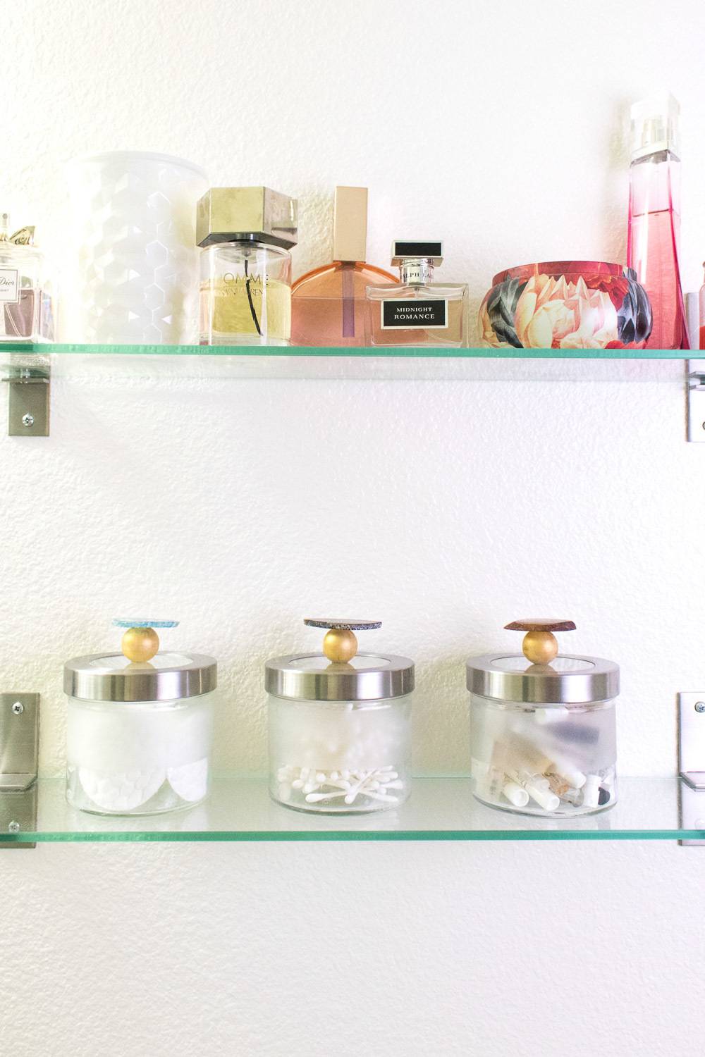 Items and perfumes sit on rows of glass shelves.