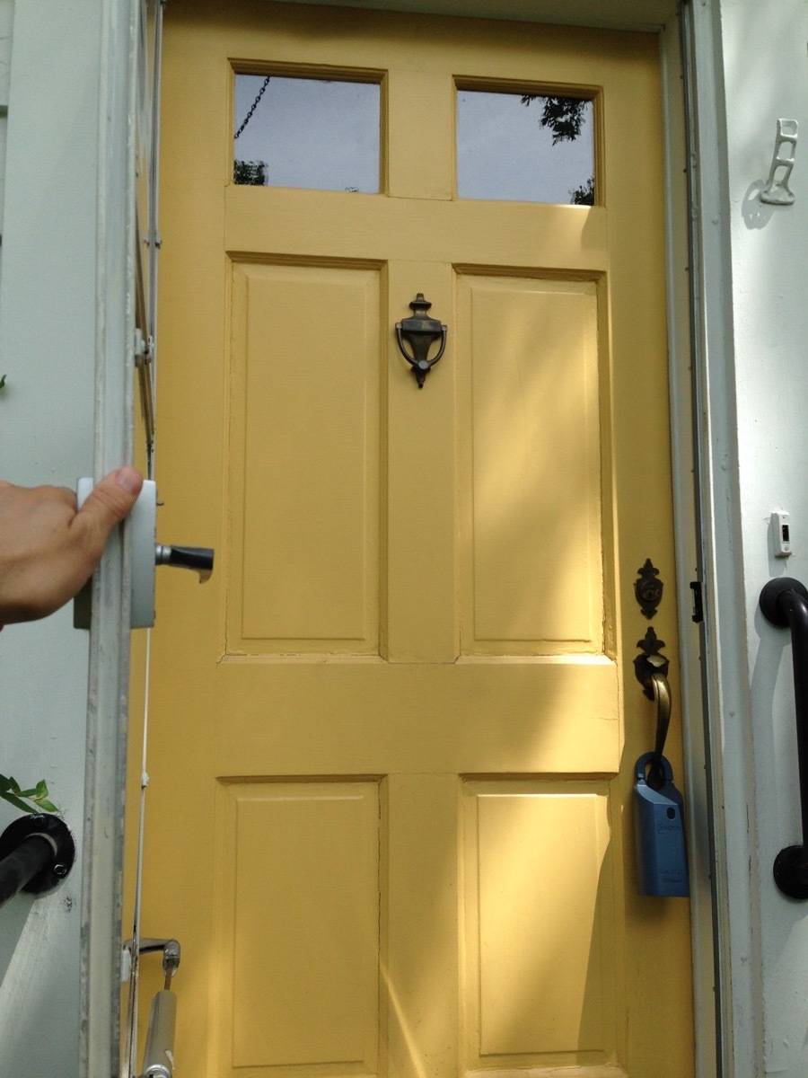 A yellow door is set into a white building.