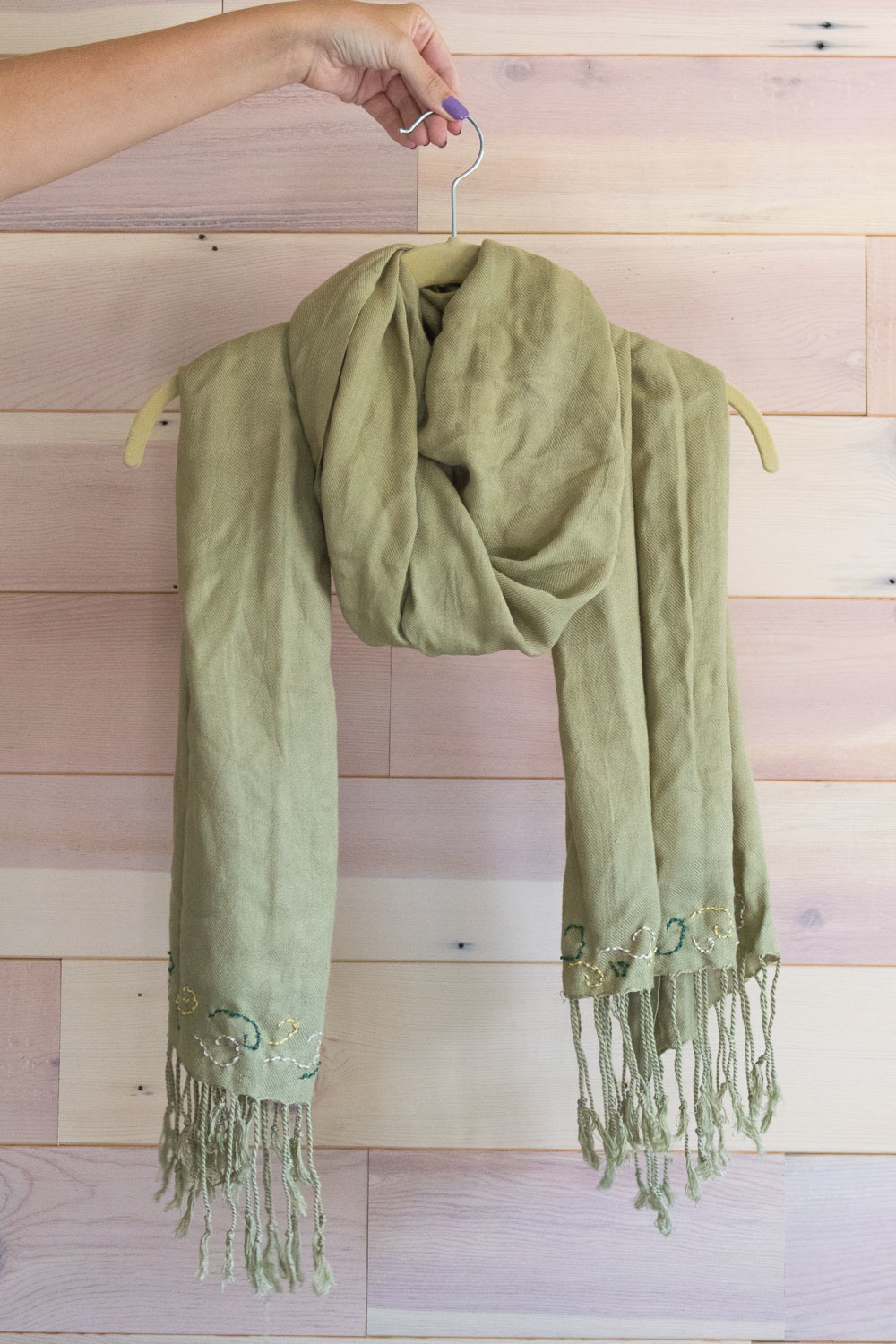 A green scarf on a hanger