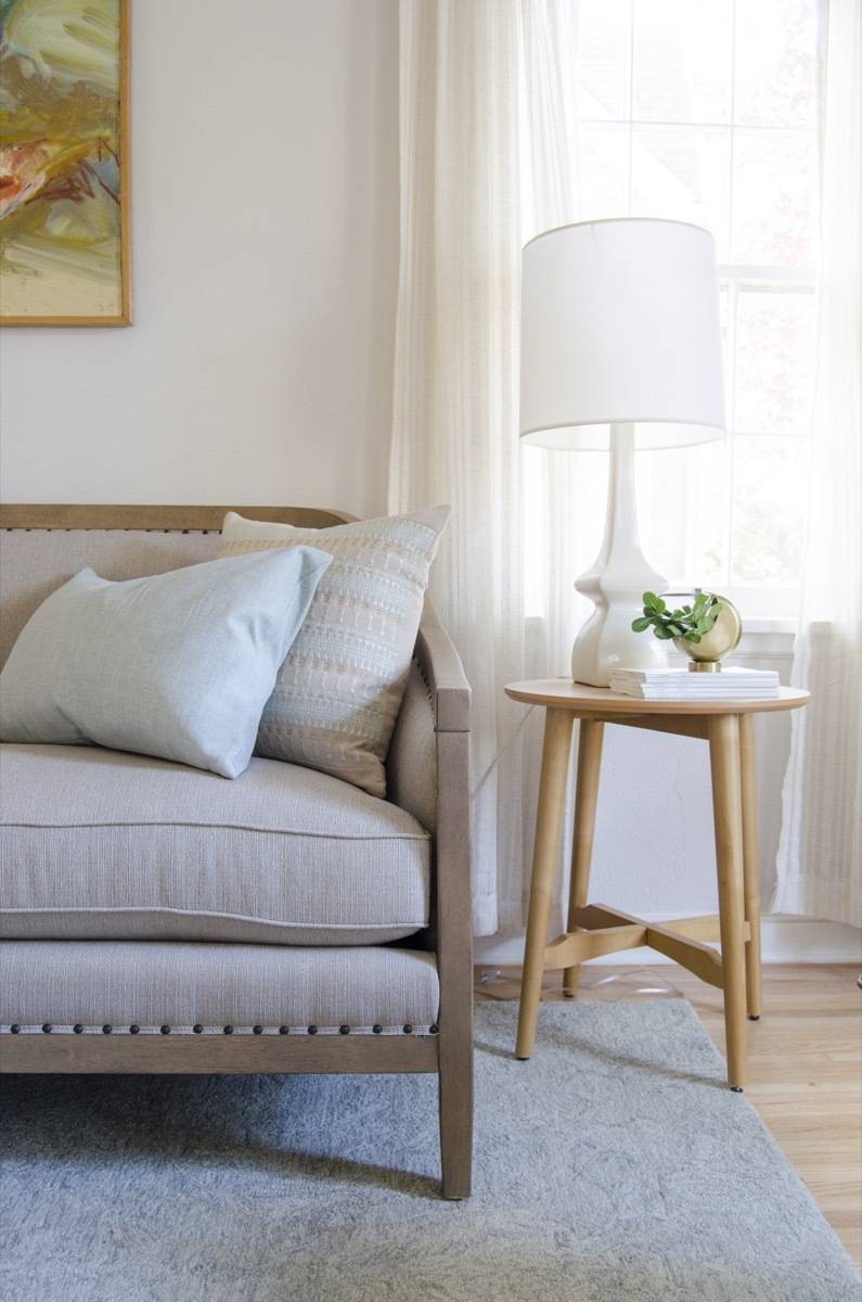 Nailhead trim sofa detail with side table and table lamp