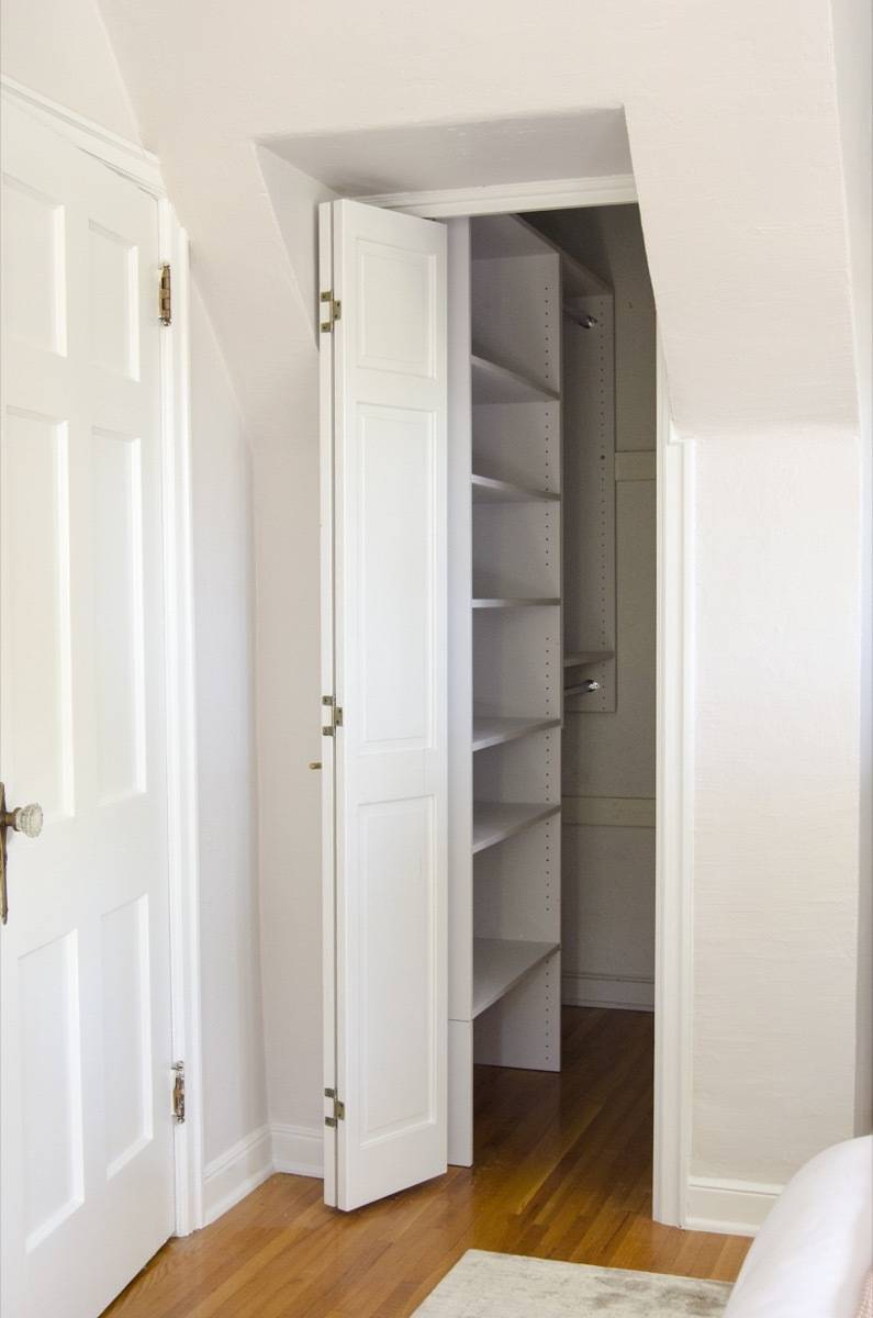 A door to a closet with empty shelves inside.