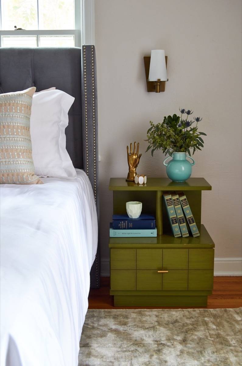 Green vintage bedside table with wall sconce