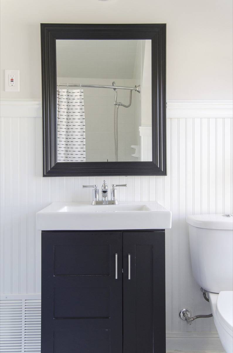 Small bathroom with shallow vanity and black and white color scheme