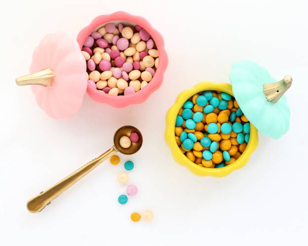 Desert candy is served in pink and yellow containers.