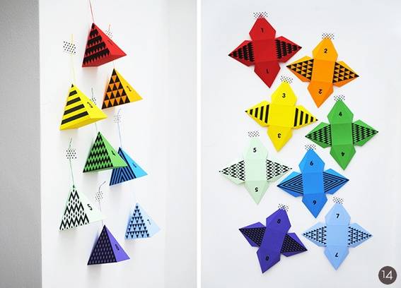 A wall has colorful decorative origami art on it.