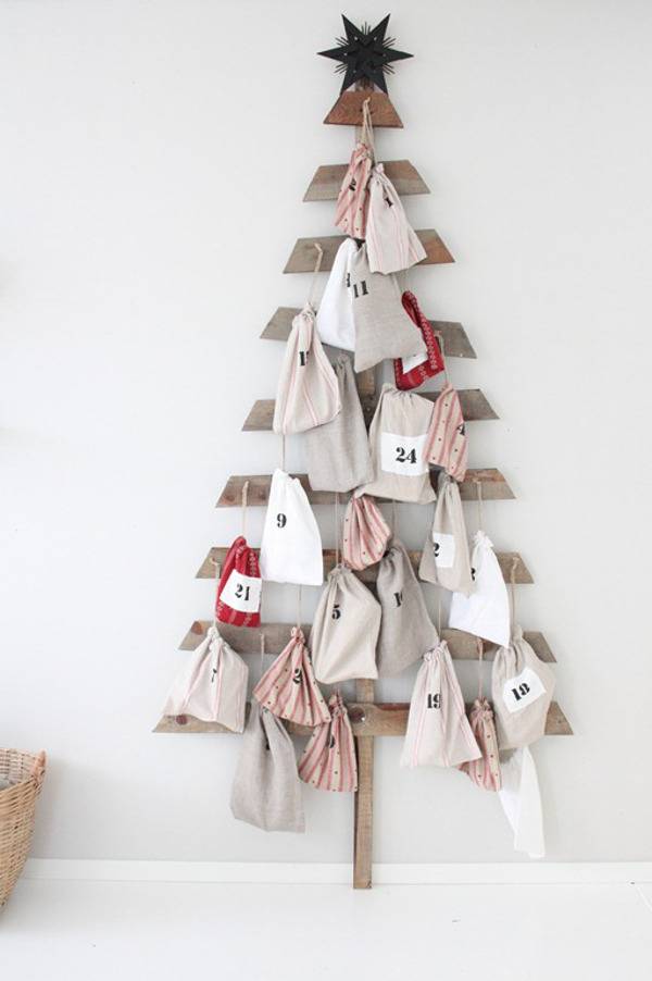 A Christmas tree on the wall is made out of many materials.