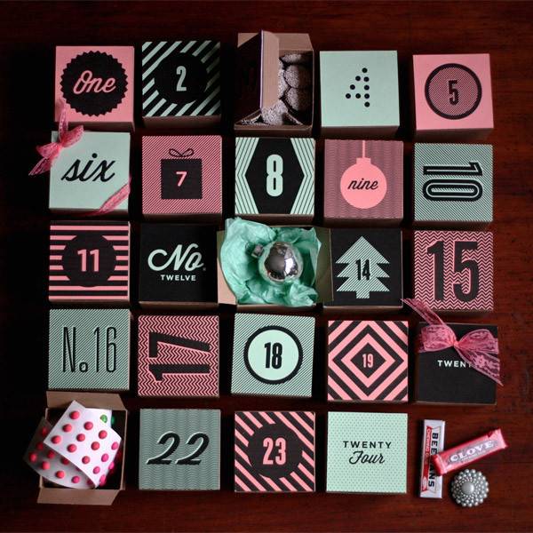 Numbers in various fonts with patterns on square tiles in pink, black, and teal create an advent calendar.