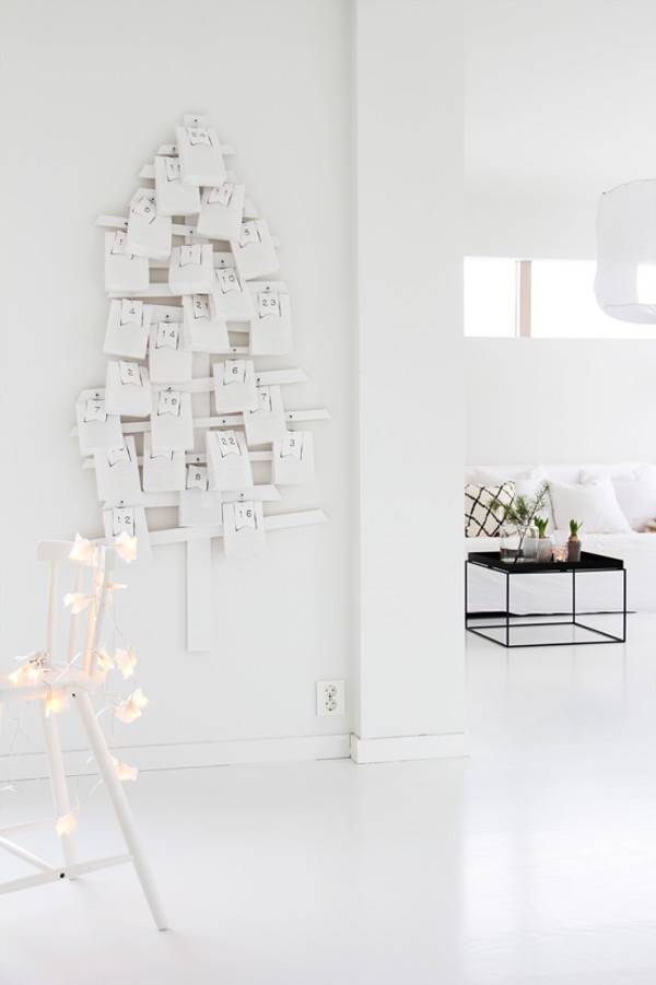 White wooden advent calendar on wall near side table in living room.