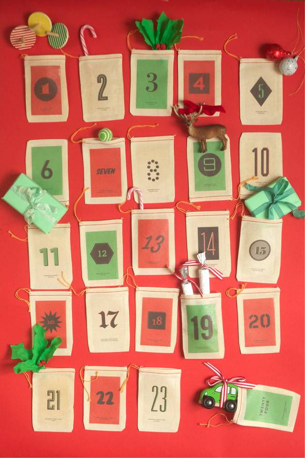 A holiday calendar has been made on a large piece of poster board with attached pockets to hide things in for every day of the month of December.