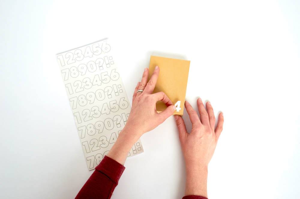 Two hands folding yellow paper